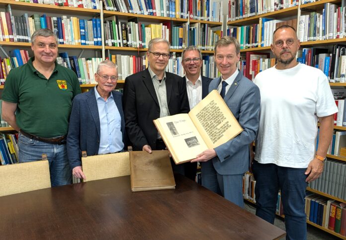 2026-07-01Stadtarchiv Gedenkbuch Lintorf Bei der Übergabe der Lintorfer Gedenkbücher im Stadtarchiv (v.l.n.r.): Uwe Springer, Lintorfer Heimatfreunde, Michael Lumer, Ratinger Heimatverein, Ratingens Stadtarchivar Dr. Sebastian Barteleit, Kulturdezernent Harald Filip, Dr. Jens Metzdorf, Stadtarchivar Neuss, und Marcus Janssens, Leiter der Bestandserhaltung des Neusser Stadtarchivs. Foto: Stadt Ratingen