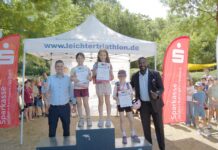 Ratingen: 1058 Kinder beim Schulsporttag Swim & Run am Start Georg Mantyk feiert „schönsten Sporttag des Jahres” – Lions Club unterstützt mit 5000 Euro Sieger auf der Treppe, Unterstützer an der Seite, Bürgermeister Patrick Anders (l), und Samuel Awasum, Präsident der Ratinger Lions (r), Bild: Oliver Kubaneck