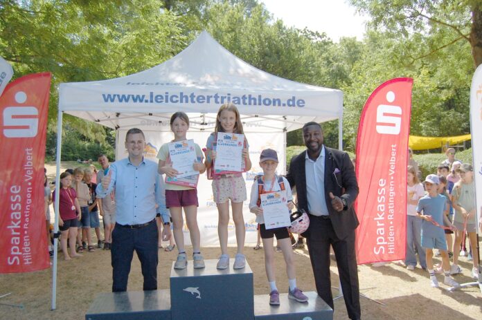 Siegerehrung Swim Sieger auf der Treppe, Unterstützer an der Seite, Bürgermeister Patrick Anders (l), und Samuel Awasum, Präsident der Ratinger Lions (r), Bild: Oliver Kubaneck