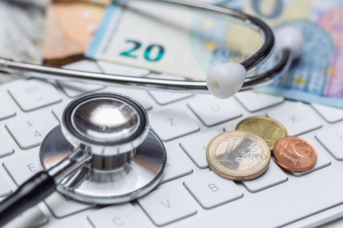 Stethoscope and keyboard with coins and money concept Künftig werden Mitglieder nicht mehr über die Erhöhung des Krankenkassenbeitrags informiert. Foto: Verbraucherzentrale NRW