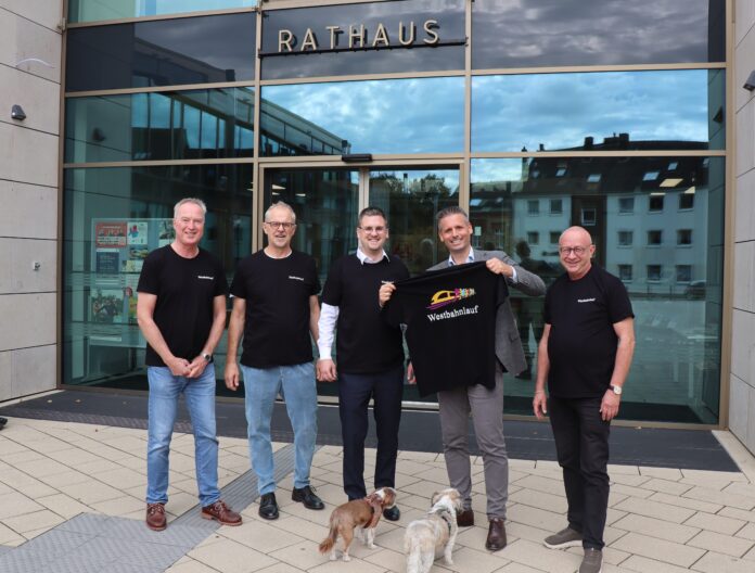 2026-09-17T-Shirts Westbahnlauf Freuen sich über die Westbahnlauf-T-Shirts (v.l.n.r.): Thomas Frühbuss, André Tünkers (beide InWest), Bürgermeister Patrick Anders, Julian Straßburger, Geschäftsführer bei Amand, und Prof. Dr. Jürgen Erbach von IPEM. Foto: Stadt Ratingen